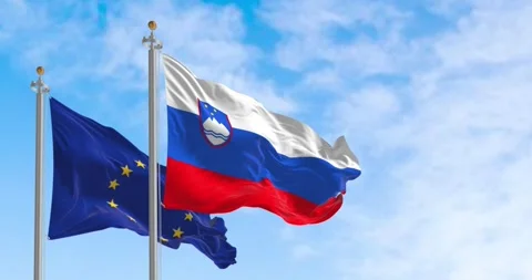 Seamless loop in slow motion of Slovenia and the EU flags waving on a clear d Stock Footage 244214735