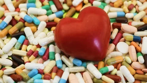 Seamless loop of spinning heart among medication pills Stock Footage 95477102