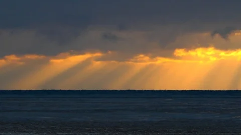 Seamless loop, time lapse sky over icy lake with sunbeams penetrating through Video stock 101254745