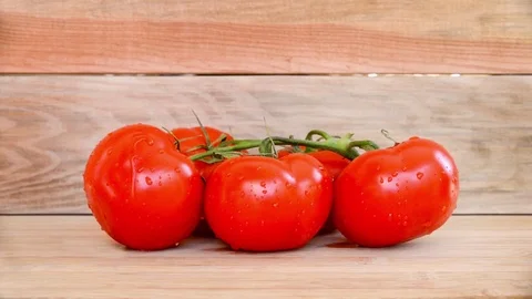 Seamless loop, tomatoes on wooden planks background, water trickles Video stock 73856784