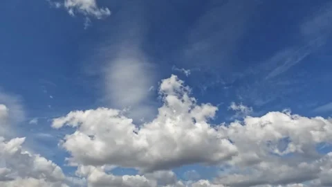 Seamless Loop of White Puffy Clouds Floating Across Bright Blue Sky Daytime Stock Footage 332501601