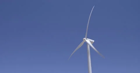 Seamless loop of wind turbine against a blue sky 4K Stock Footage 63846434