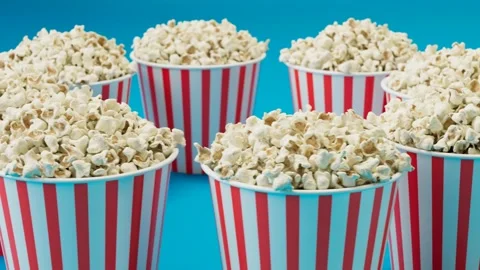 Seamless looping animation of full popcorn buckets. Boxes are spinning around. Video stock 133470877