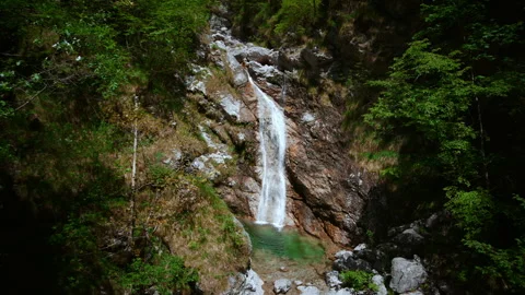 Seamless looping cinemagraph of a wild alpine waterfall flowing into a Stock Footage 342066008