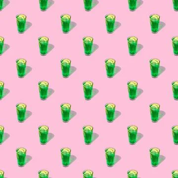 Seamless looping pattern with a transparent glass of green drink on a pastel  Stock Photos