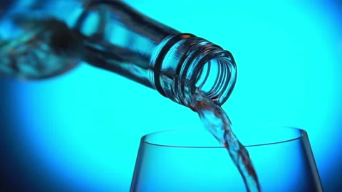 Seamless looping wine pouring from bottle into glass blue background close up Stock Footage 138645049
