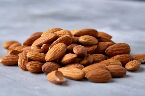 Seamless pattern with almond on the gray background, flat lay, close-up. Stock Photos