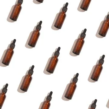 Seamless pattern of anti aging serum in glass bottle with dropper on white .. Stock Photos