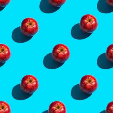 Seamless pattern of apples on a blue background. Healthy snack background. Stock Photos