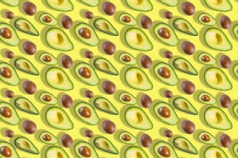 Seamless pattern of avocado fruit halves and bones isolated on yellow background Stock Photos