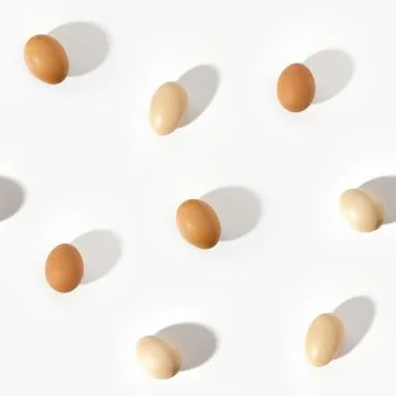 Seamless pattern with beige chicken eggs on light white background Foto stock