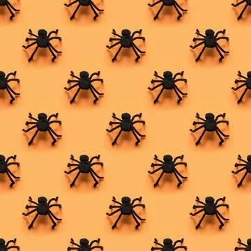 Seamless pattern of black different spiders on orange. Halloween background. Stock Photos