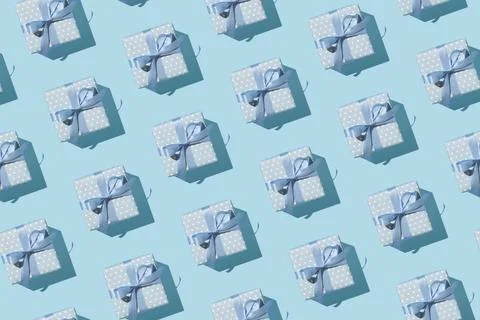 Seamless pattern of blue gift boxes with ribbon bows on pastel background. Mi Stock-Fotos