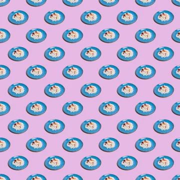 Seamless pattern from blue plates with cottage cheese on a pink background. Stock Photos