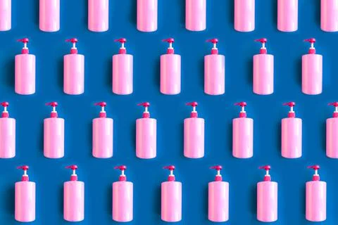 Seamless pattern of bottles with pink dishwashing liquid and sponges on blue  Stock Photos