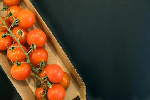 Seamless pattern with cherry tomatoes. Abstract background. Tomato on the black Foto stock