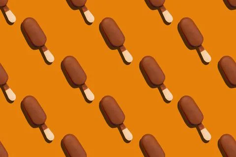 Seamless pattern of a chocolade glazed eskimo on an orange background Stock Photos