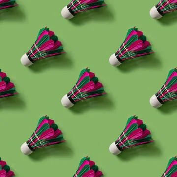 Seamless pattern of colorful badminton feather shuttlecock on green . Stock Photos