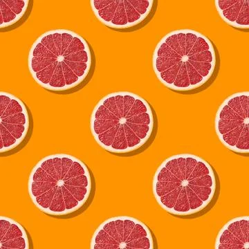 Seamless pattern of colorful grapefruit slices on orange background. Bright Stock Photos