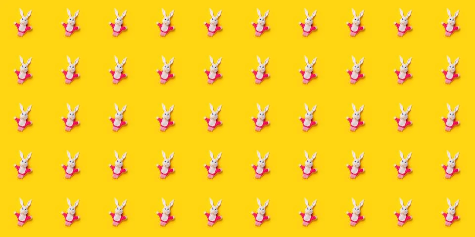 Seamless pattern. Easter bunnies isolated on yellow background. Funny texture Stock Photos