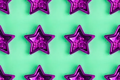 Seamless pattern from five pointed purple metallic star on pastel green surface. Stock Photos