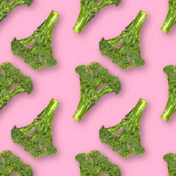 Seamless pattern with fresh broccoli with water drops isolated on pink backgr Stock Photos