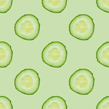 Seamless pattern of fresh cucumber slices isolated on green background. Top view Stock Photos