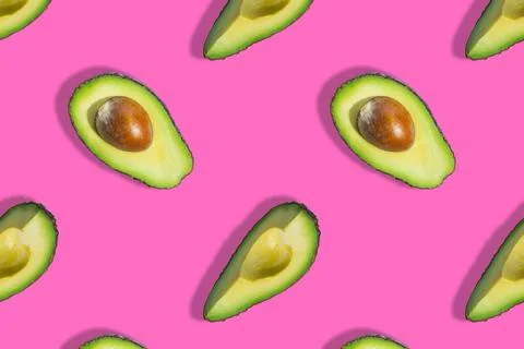 Seamless pattern of fresh green avocado fruit half isolated on pink background Stock Photos