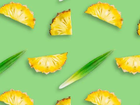 Seamless pattern of fresh ripe pineapple slices isolated on green background Stock Photos