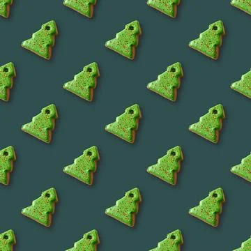 Seamless pattern of gingerbread in shape Christmas tree on green. Stock Photos