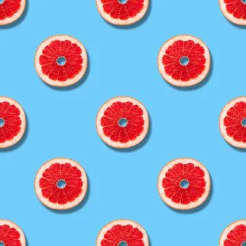 Seamless pattern with grapefruit on a blue background. Grapefruit slices  Stock Photos