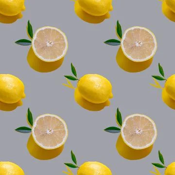 Seamless pattern with lemon cut and whole with leaves on a gray background Fotos de archivo