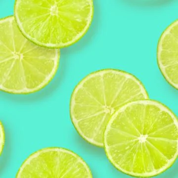 A seamless pattern of lime slices on a vibrant teal blue background, a fruity Foto stock