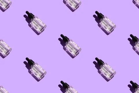 Seamless pattern of liquid oil serum bottle isolated on violet background Stock Photos