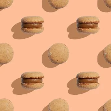 Seamless pattern with macaroons on a peach fuzz or beige background Foto stock