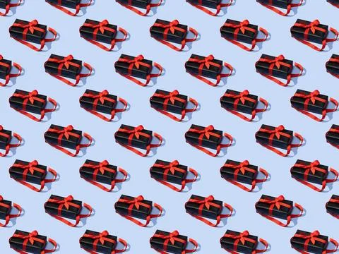 Seamless pattern made of black gift boxes tied with red ribbons on blue Stock Photos