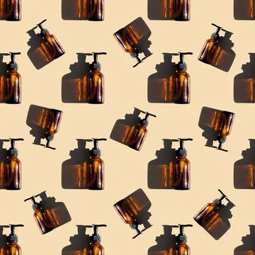 Seamless pattern made with brown glass bottle with pump of cosmetic products  Foto stock