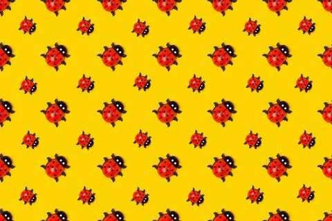 Seamless pattern made with ladybugs on yellow background, as backdrop or text Stock Photos