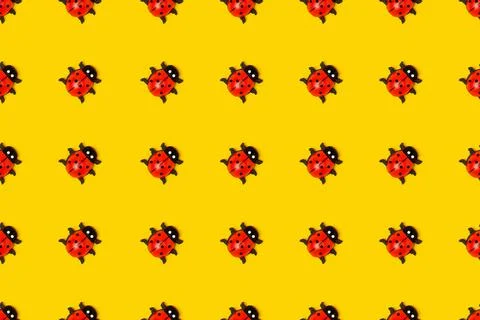 Seamless pattern made with ladybugs on yellow background, as backdrop or text Stock Photos