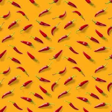 Seamless pattern made of red chili or chilli on orange background. Minimal fo Stock Photos