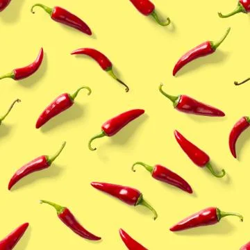 Seamless pattern made of red chili or chilli on yellow background. Minimal fo Stock Photos