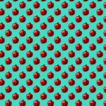 Seamless Pattern made with ripe pomegranate on green color background. Stock Photos