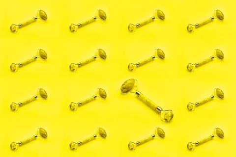 Seamless pattern. Massage roller for face with two jade stones on yellow Stock Photos