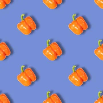 Seamless pattern with orange pepper on blue background. Vegetable pattern. Stock Photos
