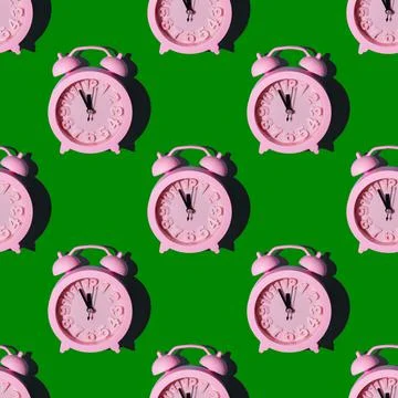 Seamless pattern with pink clocks on a green background, repeating wallpaper  Foto stock