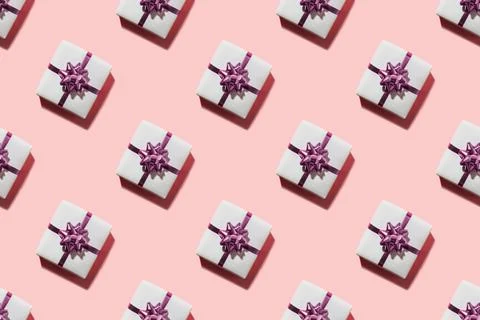 Seamless pattern of pink gifts with bow with shadow on pink. Stock Photos