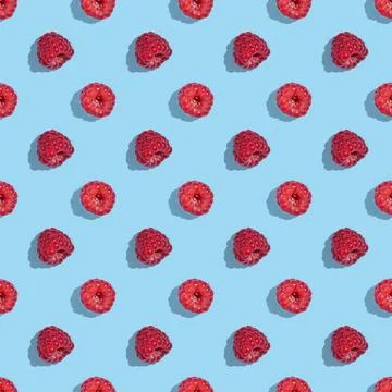 Seamless pattern from raspberry berries on a blue background. 스톡 사진