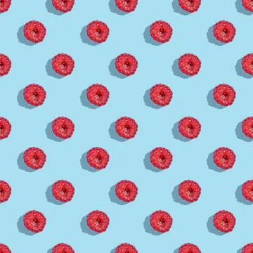 Seamless pattern from raspberry berries on a blue background. Stock Photos