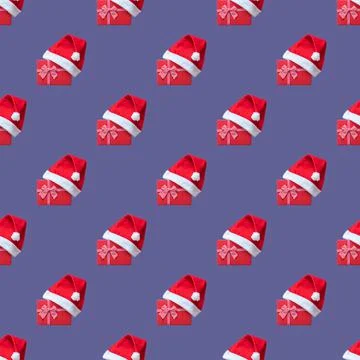 Seamless pattern with red gift box wearing Santa hat against the 2022 Very Pe 写真素材