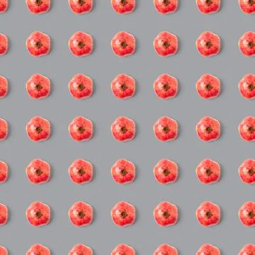Seamless pattern with red pomegranate fruit on grey background. Minimal flat lay Stock Photos